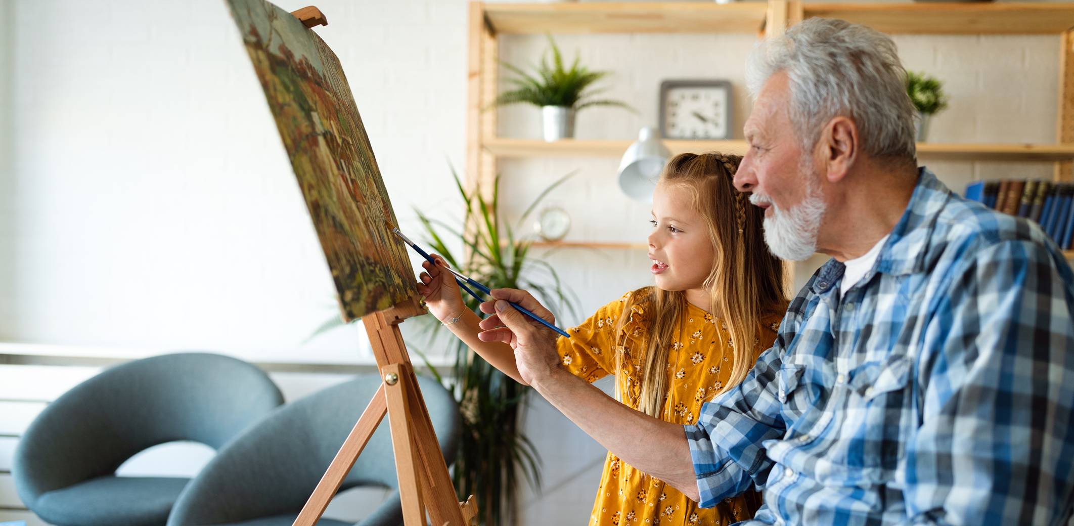 grandfather-teaching-granddaughter-to-paint