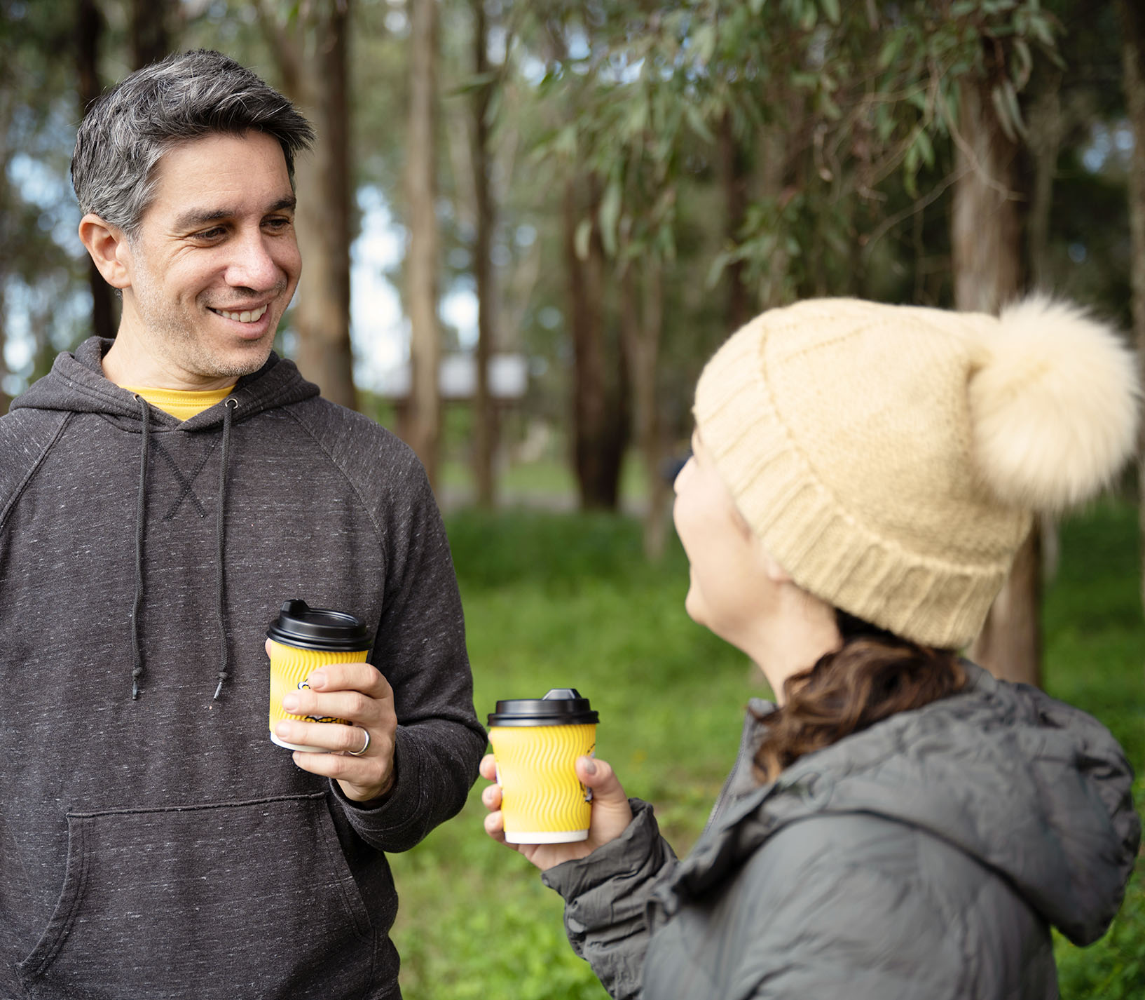 couple-outdoors-walking-with-coffee